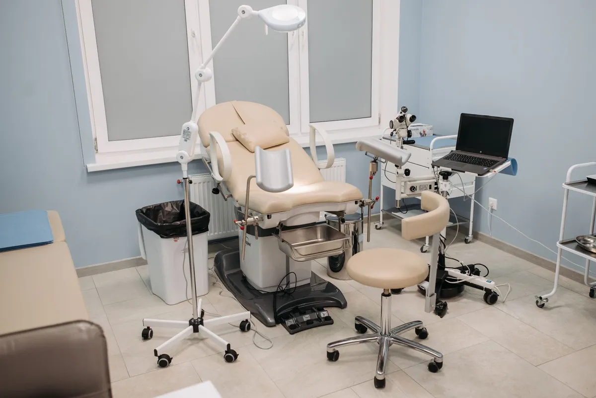 Examination room with medical equipment and a gynecological chair.