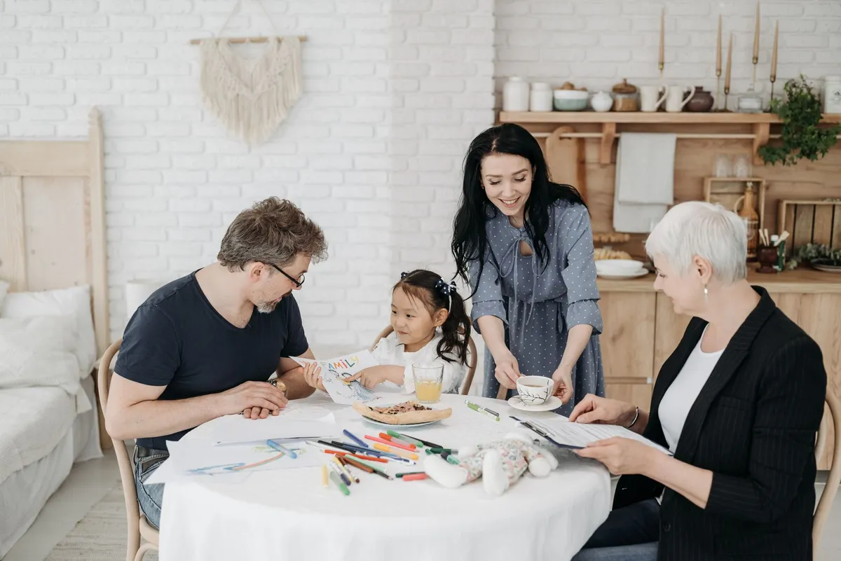 Family engaging in creative activities at a table with a child drawing and parents present.