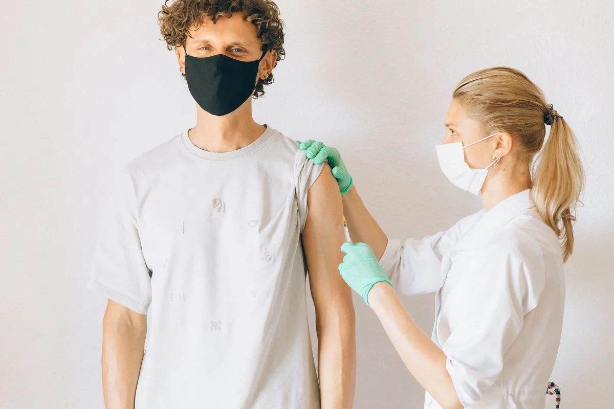Healthcare worker administering a vaccine to a patient in Grand Rapids.