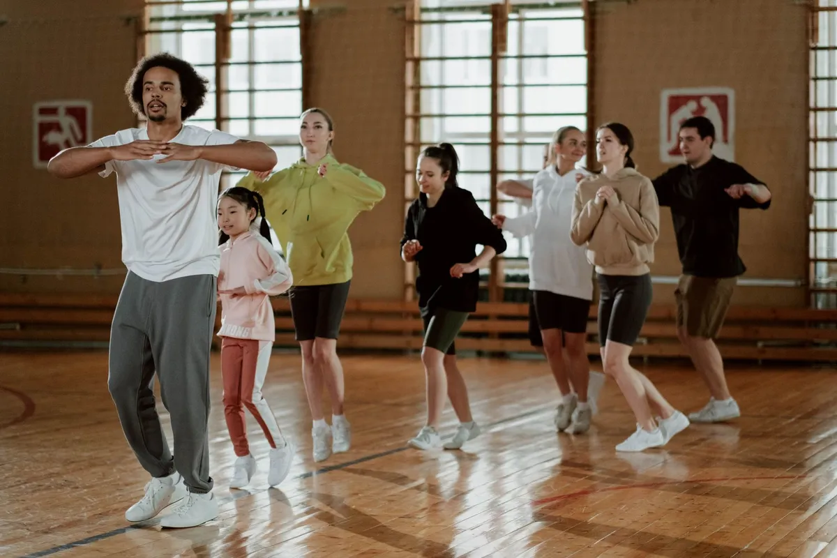 Group of people participating in an indoor aerobics class with a fitness instructor.