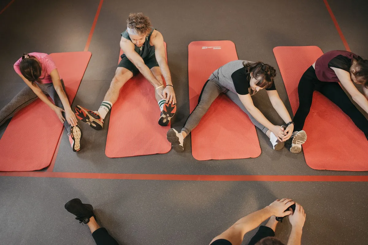Group of people stretching on mats before an aerobics class