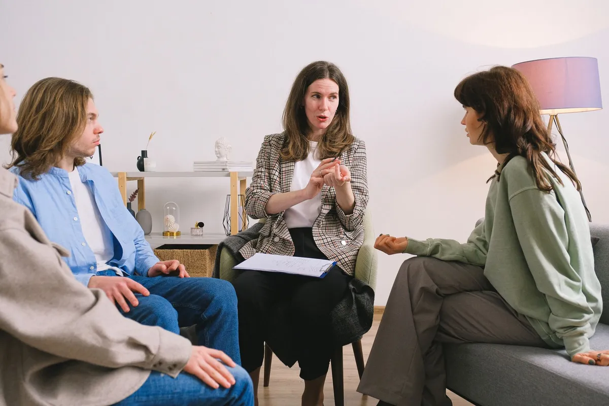 A counselor discussing with two participants in a group setting about alcohol risks.