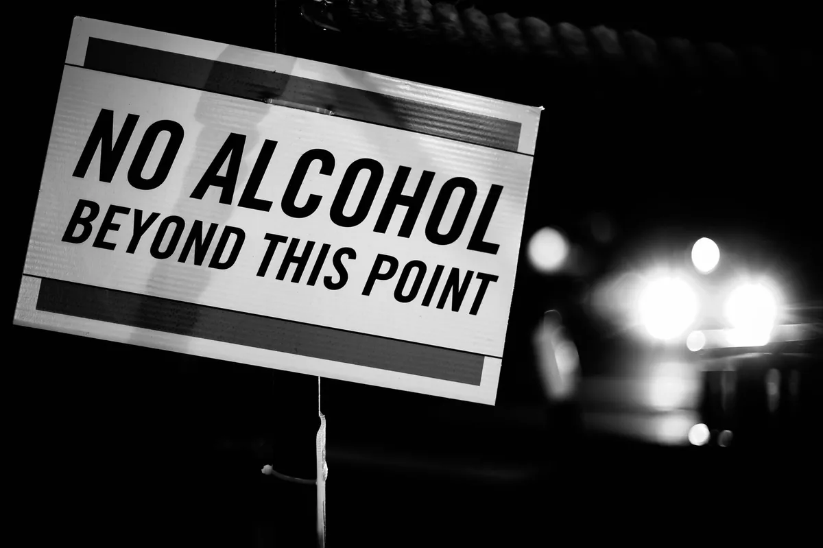 Sign stating ‘No Alcohol Beyond This Point’ in a public area.