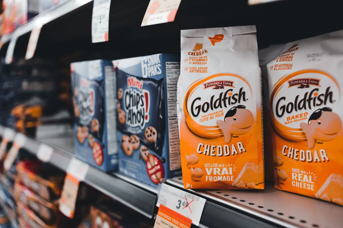 Food packages on a grocery store shelf, including allergen information.