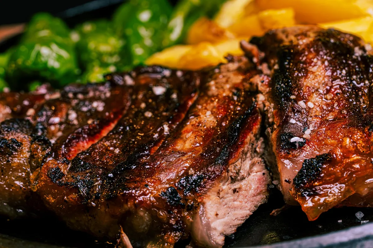 Close-up of a grilled steak with vegetables, rich in iron, on a plate.
