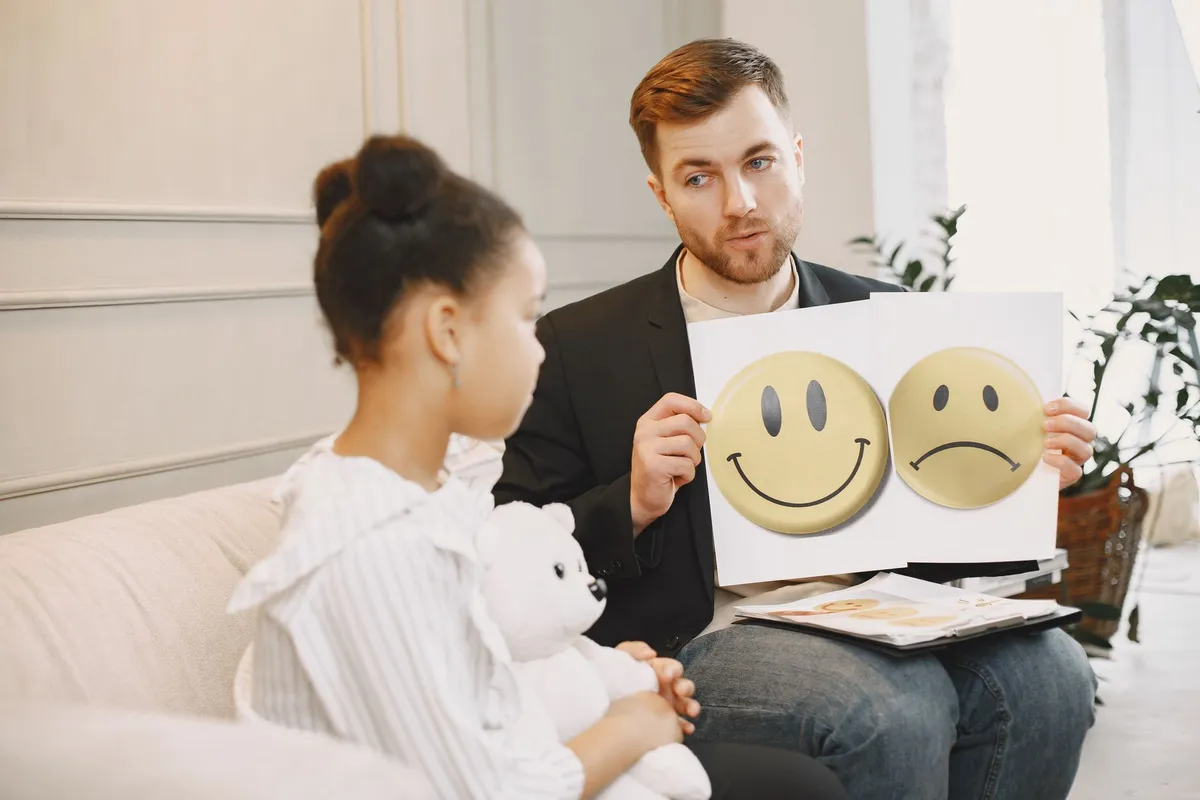 Therapist showing emotion cards to a child during a session.