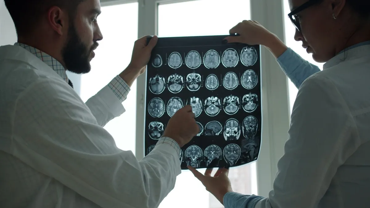 Doctors reviewing brain MRI scans in a clinical setting.