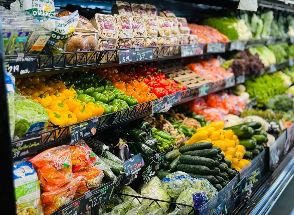 A grocery store aisle filled with fresh fruits and vegetables.