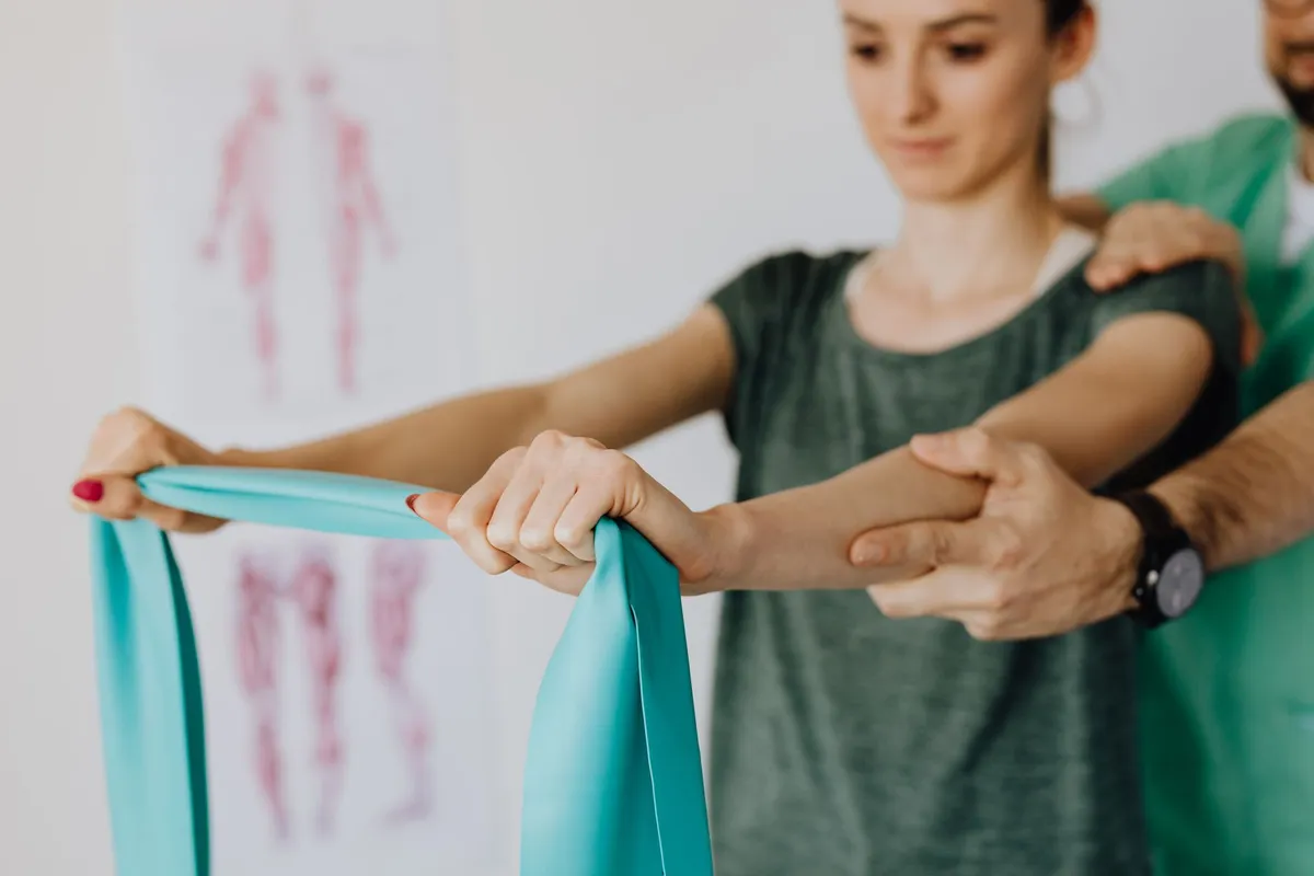 Woman performing resistance exercises with a therapist using a resistance band.