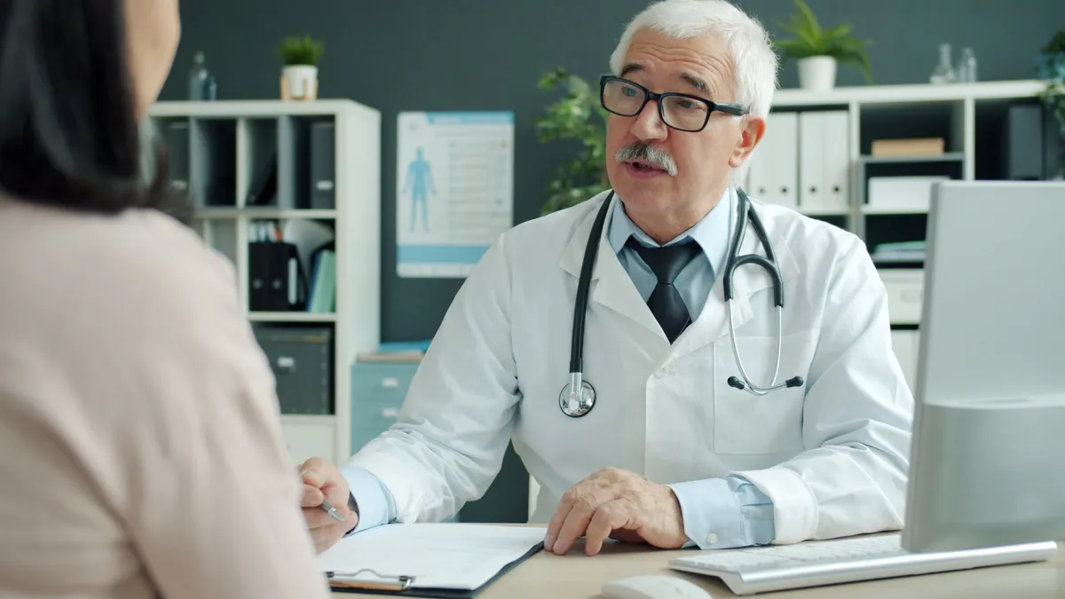 Doctor consulting with an adult patient in a medical office setting.