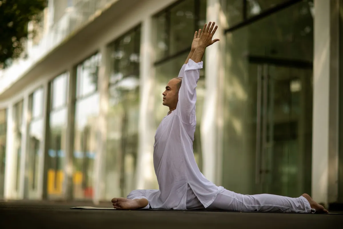 Man performing a yoga pose in a serene outdoor setting.