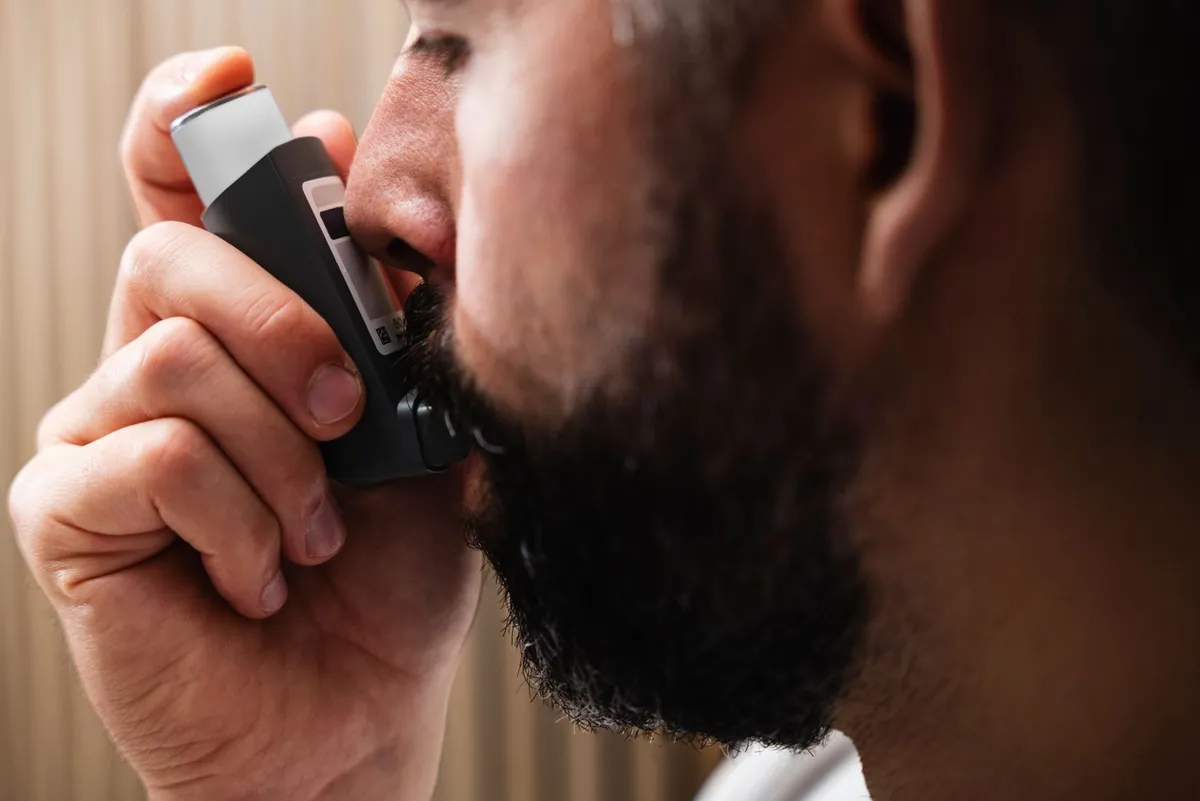 Person using an inhaler for asthma relief