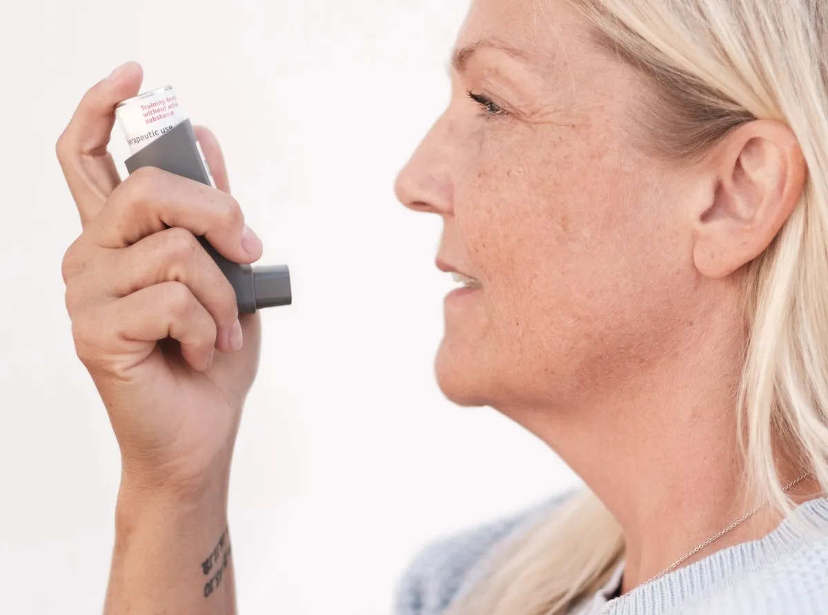 Teenager using an asthma inhaler, demonstrating proper technique for medication use.