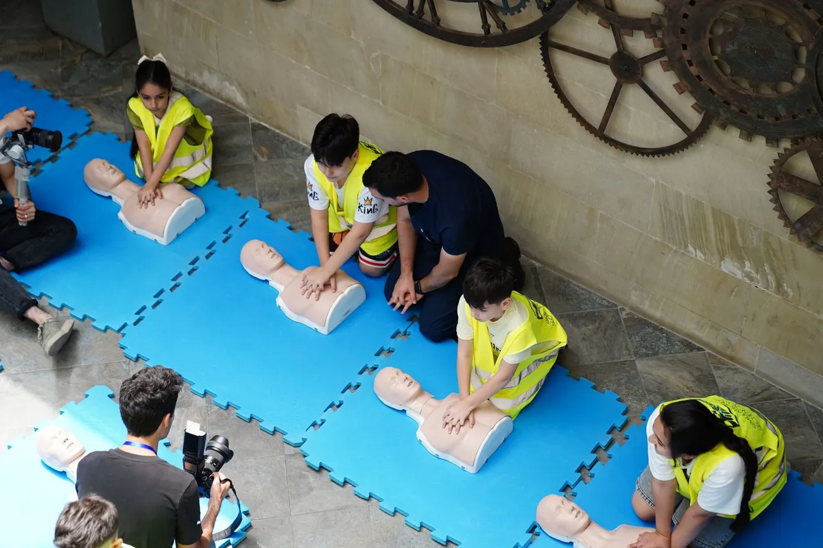 Group practicing CPR on mannequins during a first aid training session.
