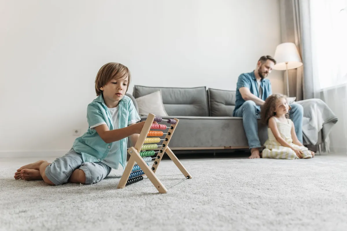 Two children playing in a clean living room with minimal clutter and dust.