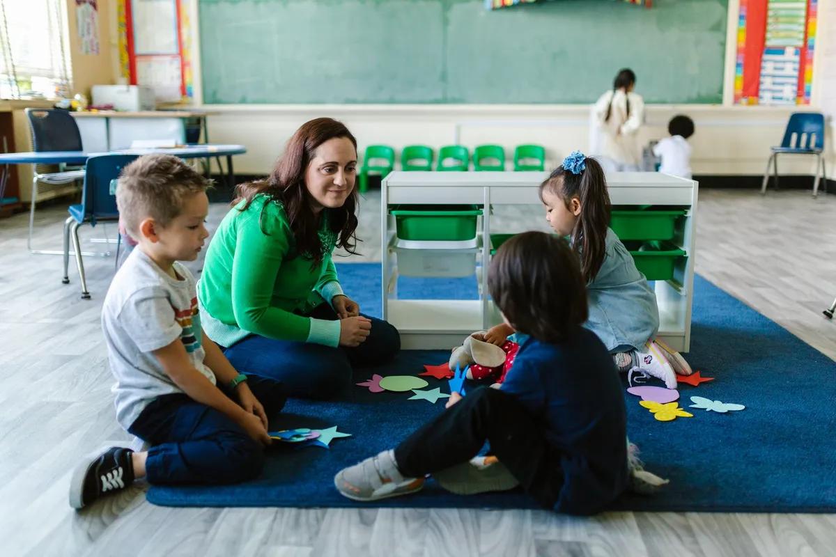 Teacher interacting with children during a classroom activity in a school setting.