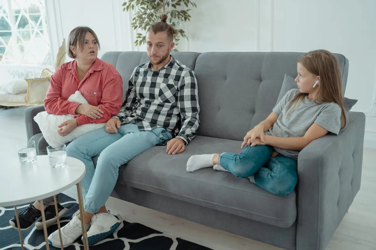 Family discussing therapy options on a couch in a bright living room.