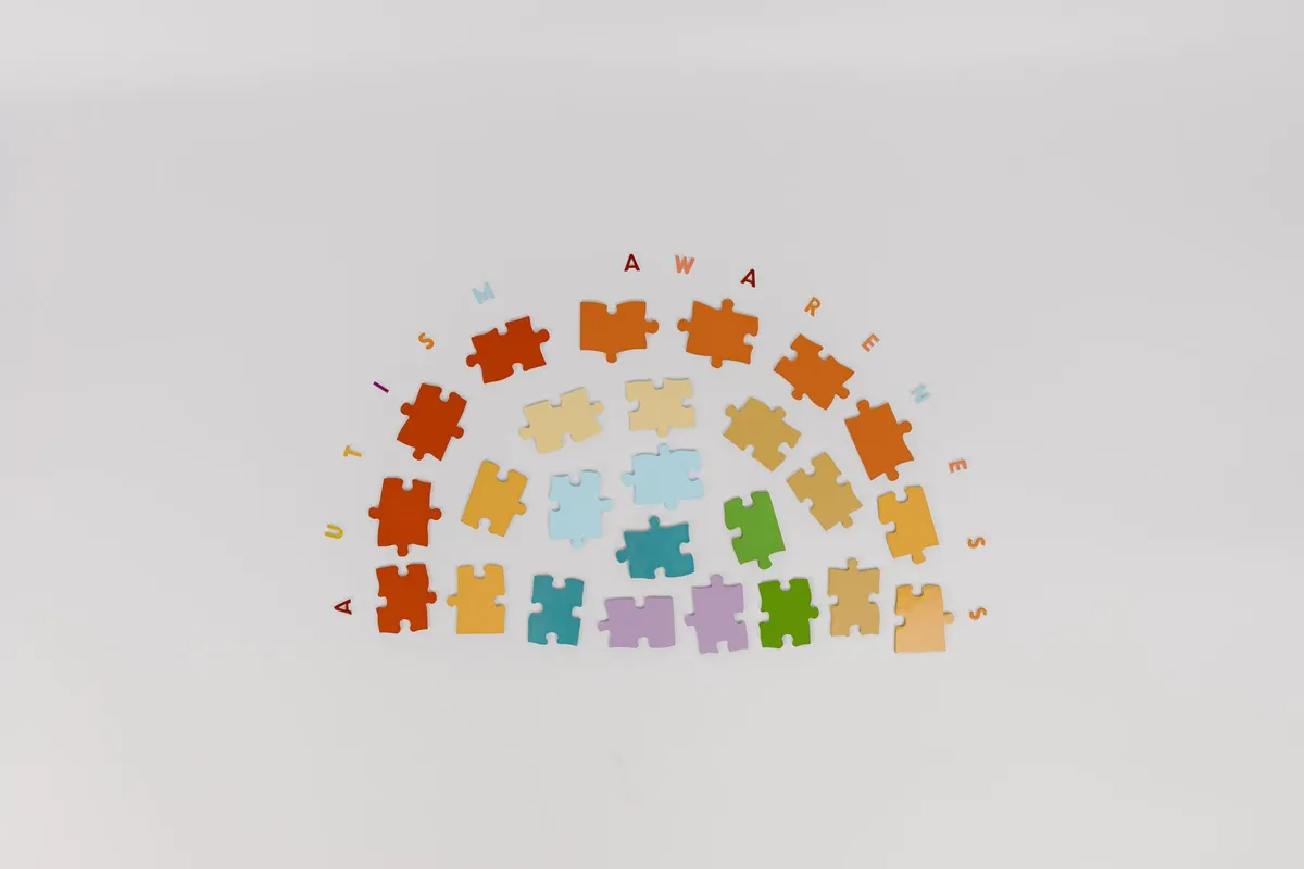 Colorful puzzle pieces arranged with the words ‘Autism Awareness’ above them.