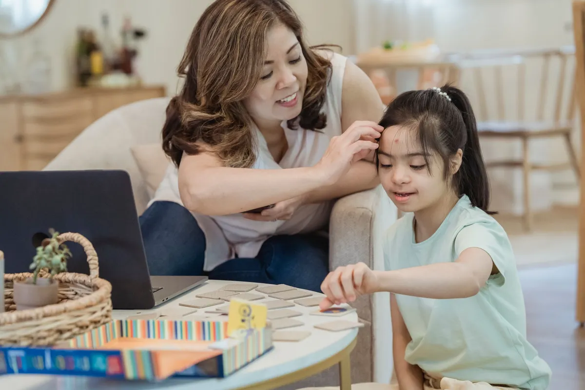 A mother and daughter engaging in a learning activity at home.