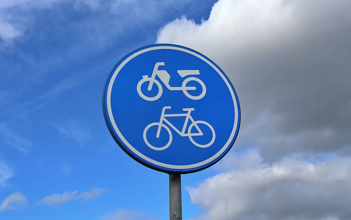 Blue road sign indicating bicycle and motorcycle paths
