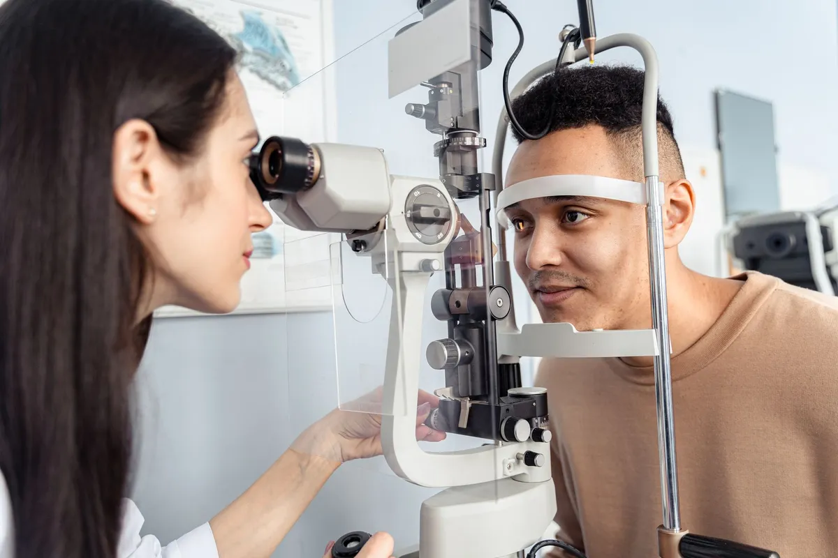 An eye doctor examining a patient using a slit lamp for eye issues.