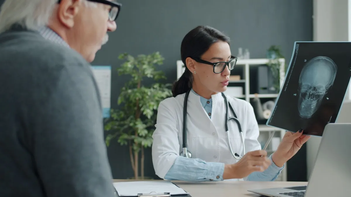 Healthcare professional explaining a brain scan to an older patient.