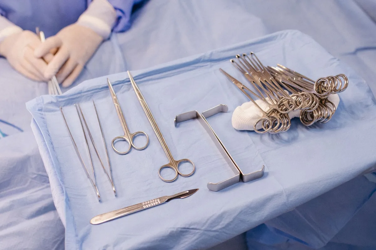 Surgical instruments arranged on a sterile drape in an operating room setting.