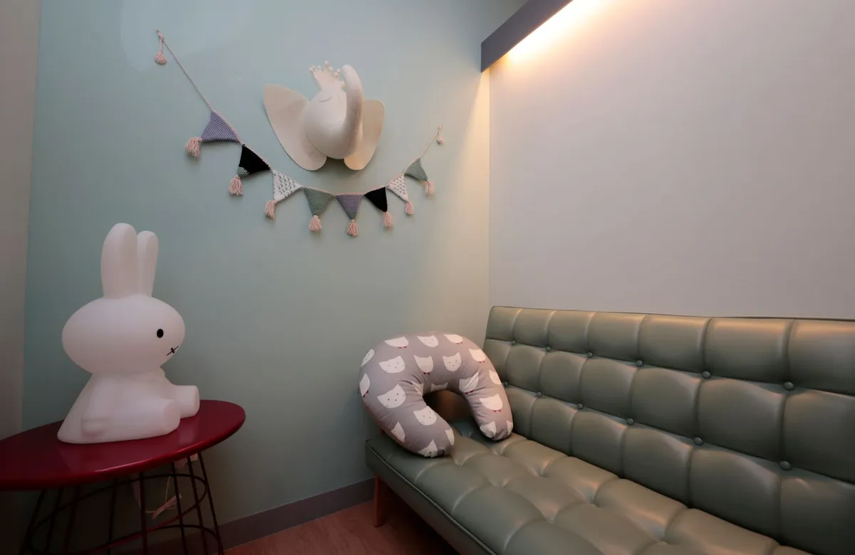 A cozy lactation room with a comfortable chair and soft decor for breastfeeding mothers.