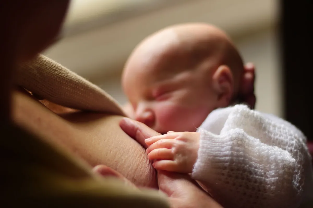 A mother breastfeeding her baby, illustrating the process of expressing breastmilk.