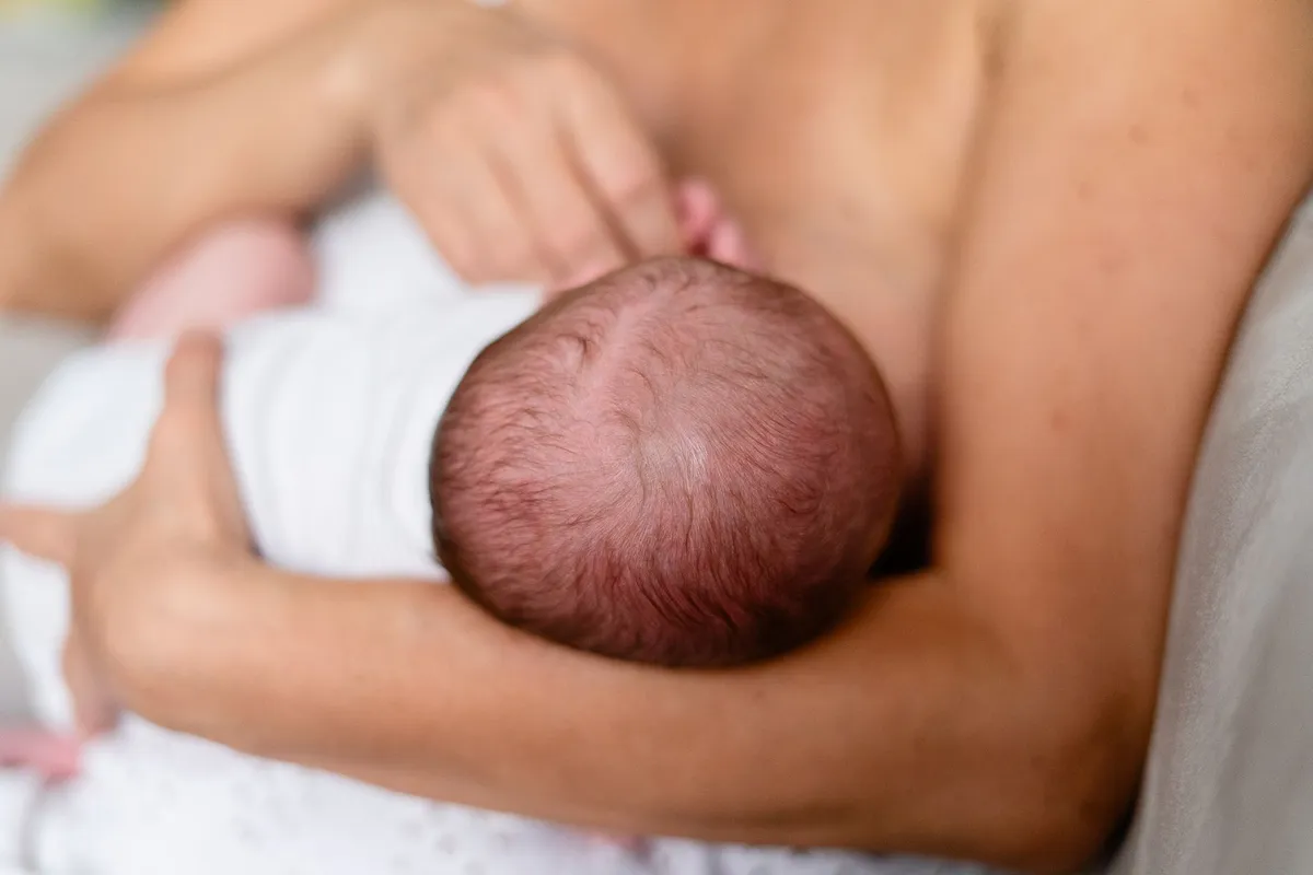 Close-up of a mother breastfeeding a baby, showing proper attachment.