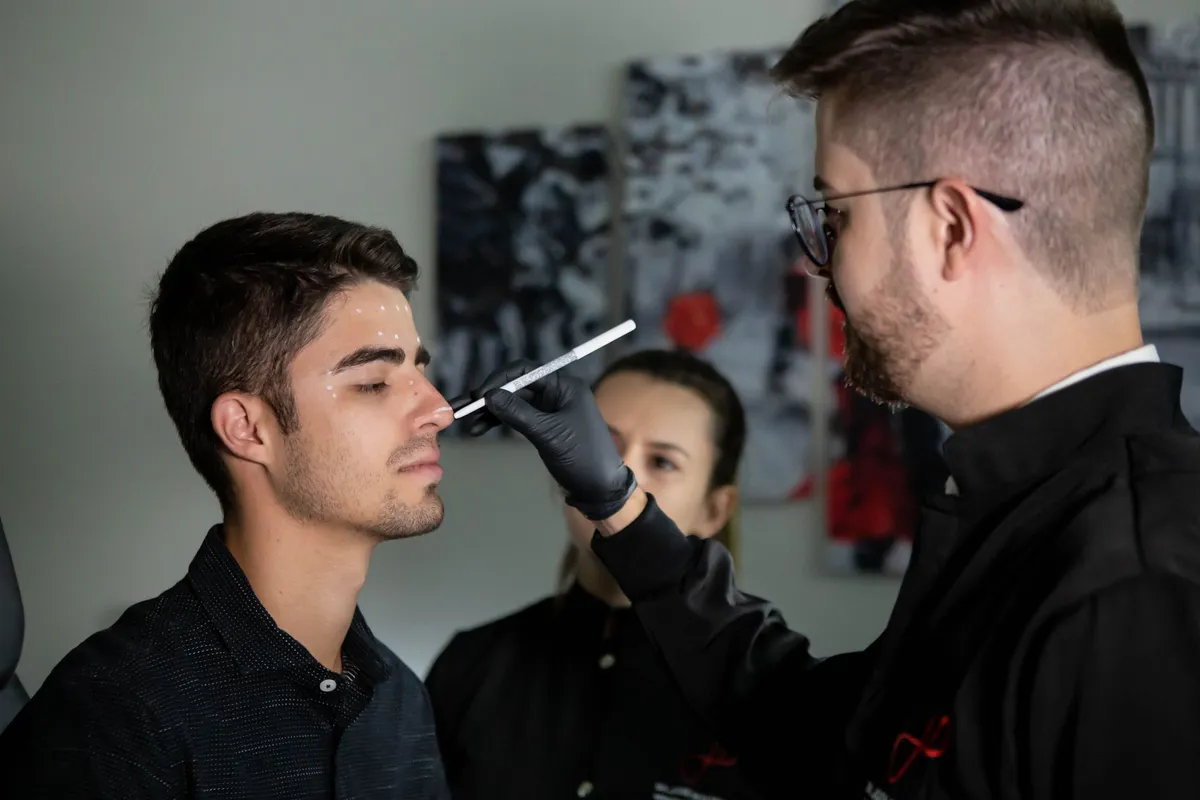 Consultation between a plastic surgeon and a patient discussing brow lift markings.