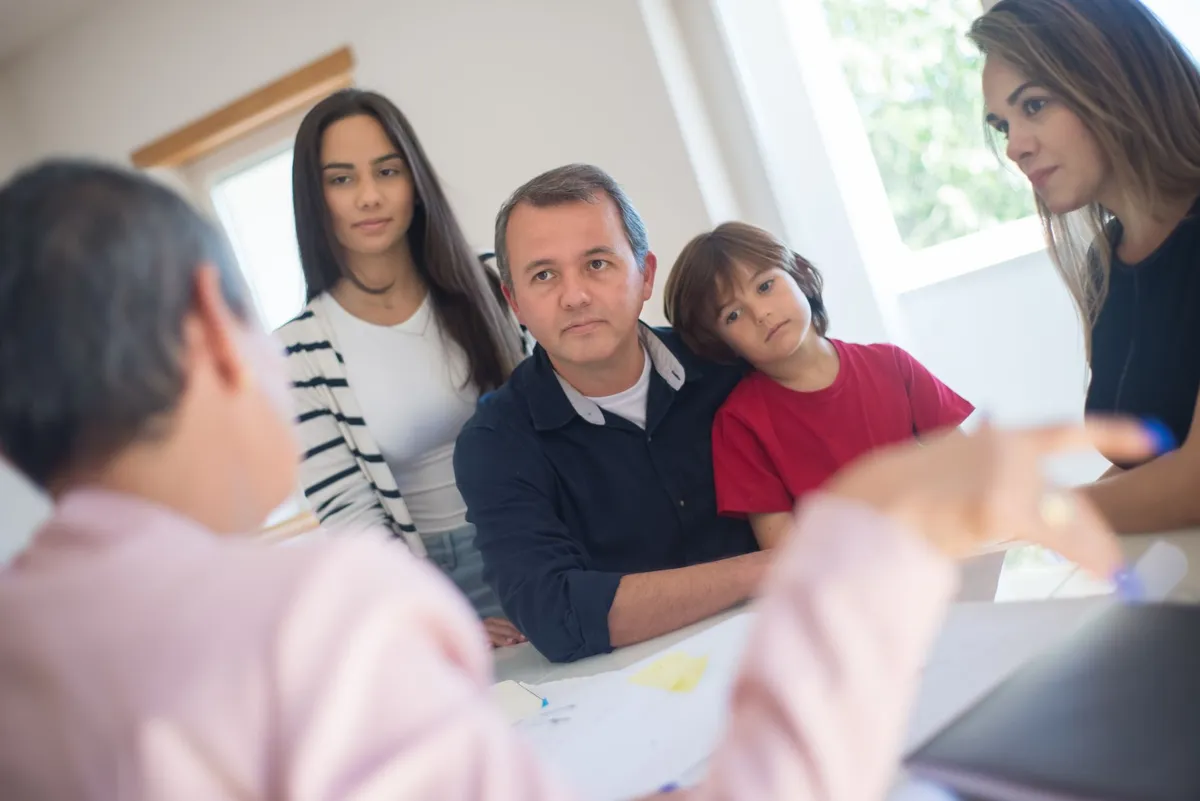 Family discussing concerns with a counselor in a supportive environment.
