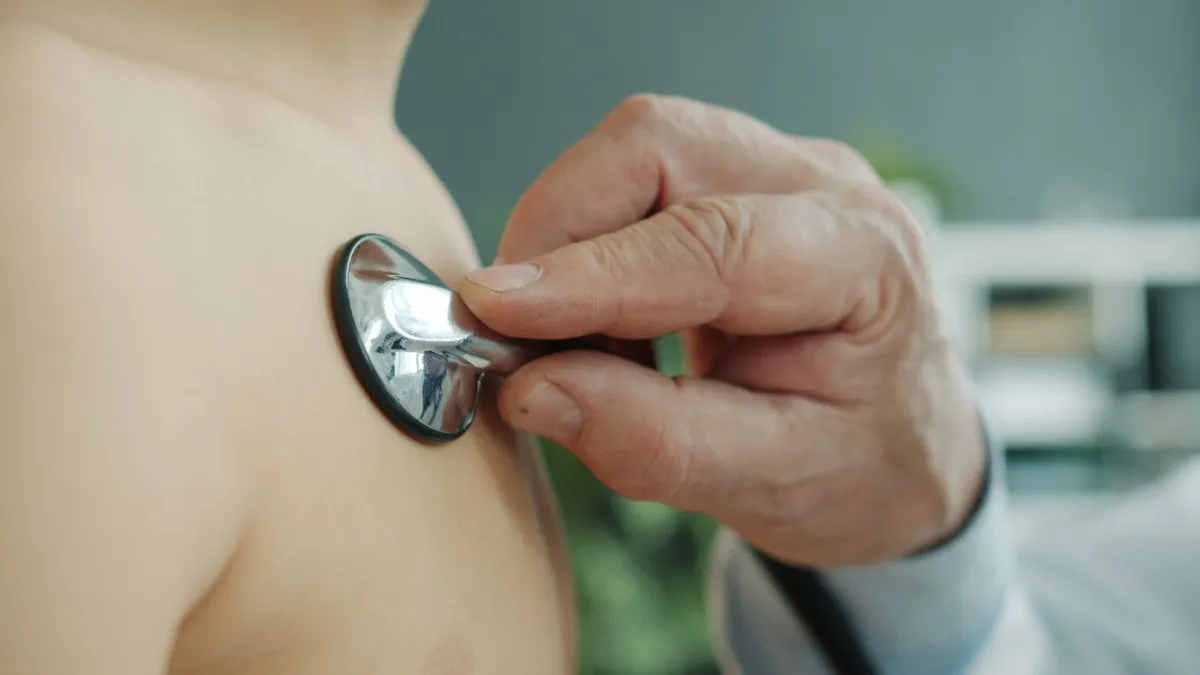 A doctor using a stethoscope on a child’s chest during a check-up.