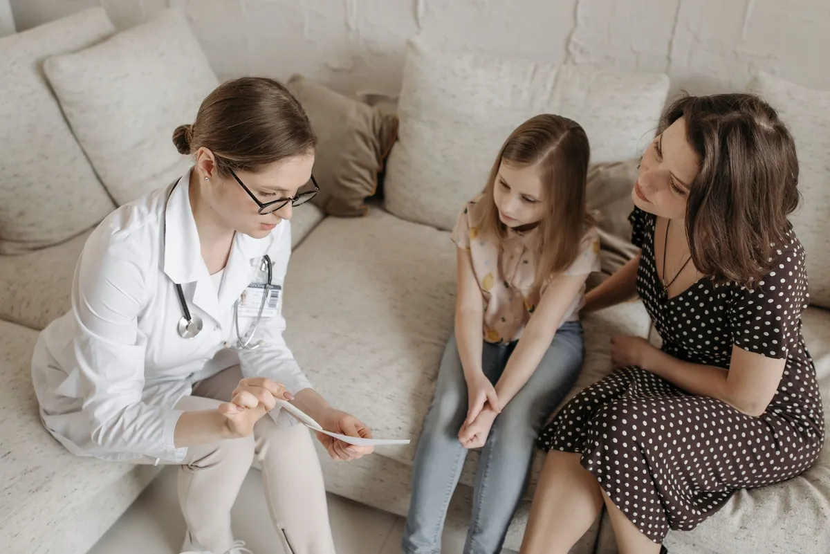 Healthcare professional discussing chickenpox prevention with a mother and daughter.