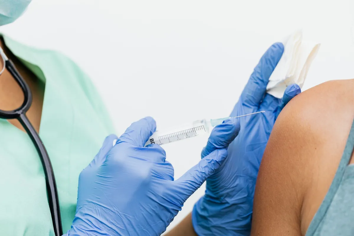 Healthcare professional administering a vaccine to a patient’s shoulder