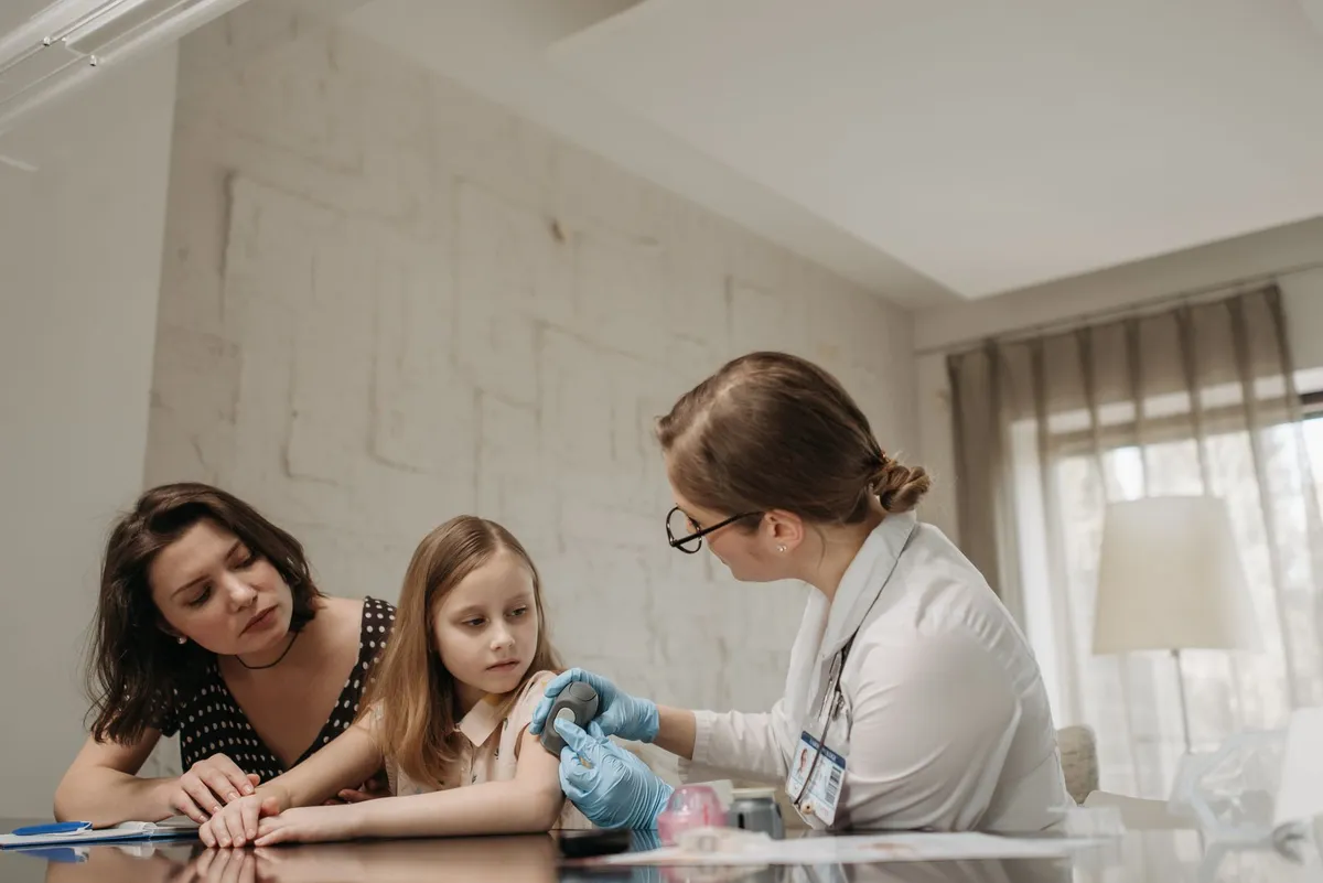 Pediatrician administering a vaccine to a child while a parent observes.