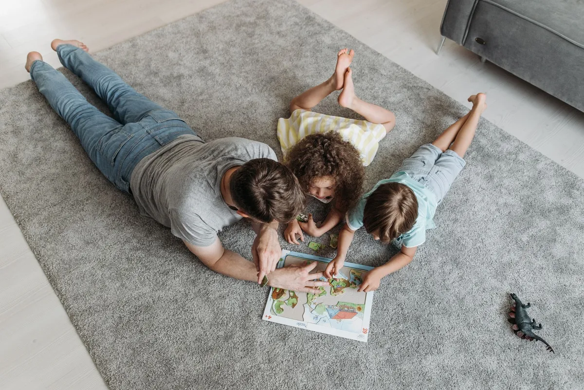 Family engaging in a fun activity, working on a puzzle together on the floor.