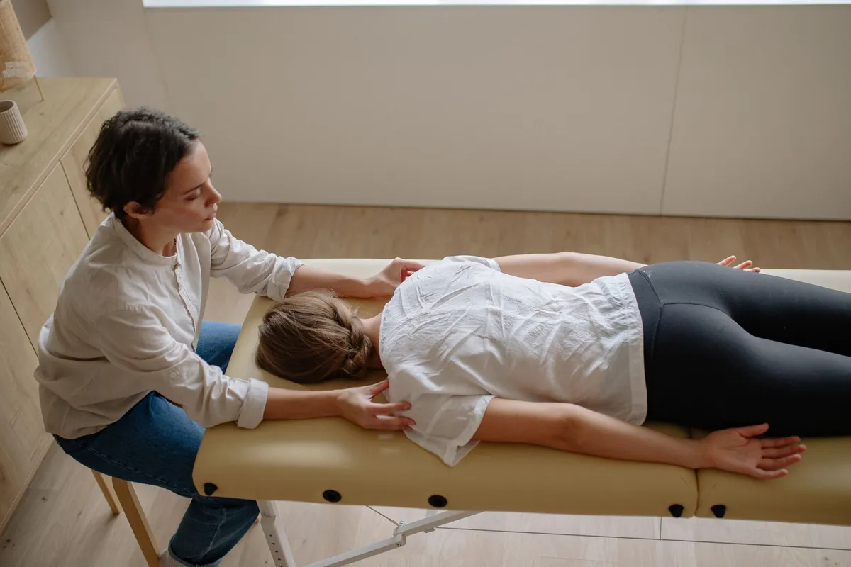 Chiropractor adjusting a patient’s neck while they lie on a treatment table.