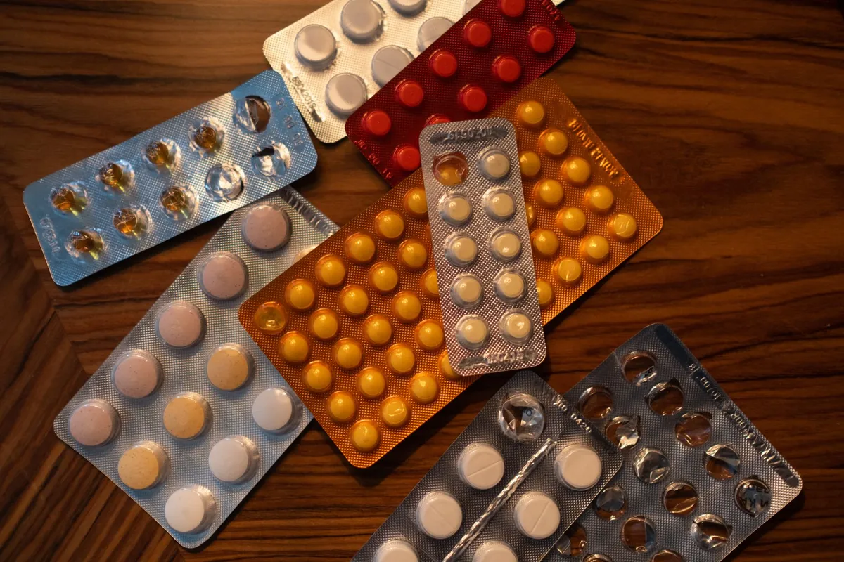 Various medication blister packs on a wooden surface
