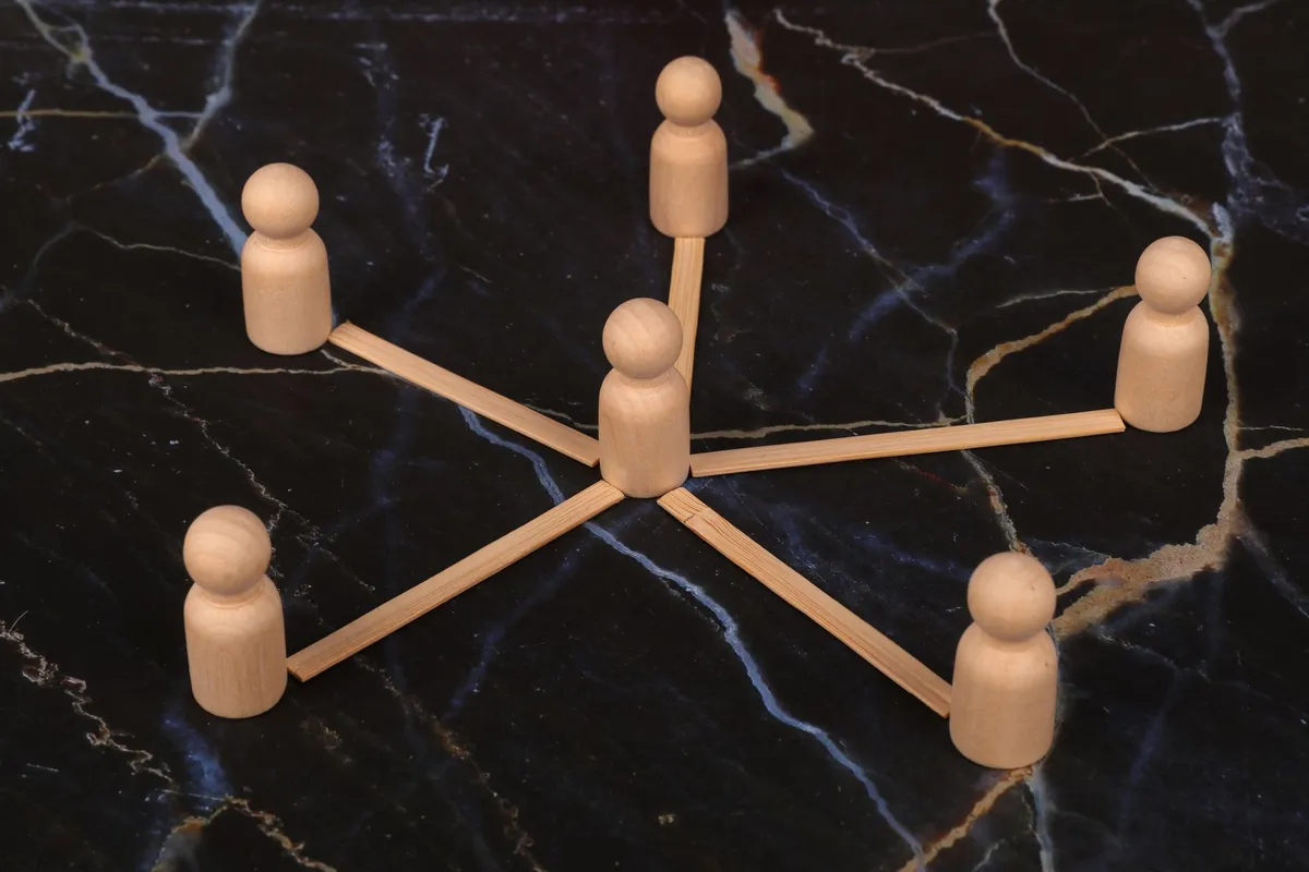 Wooden figures connected by sticks representing family dynamics.