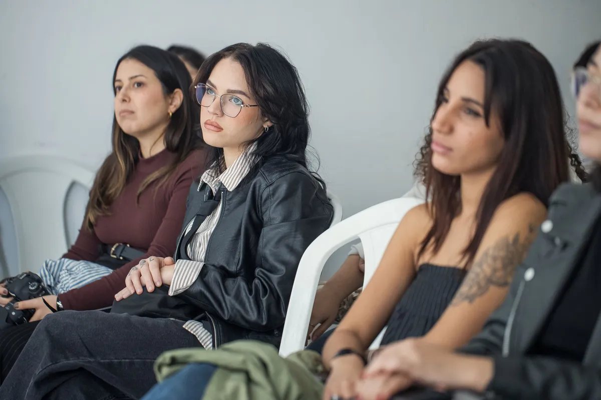 Women listening attentively in a health workshop setting.