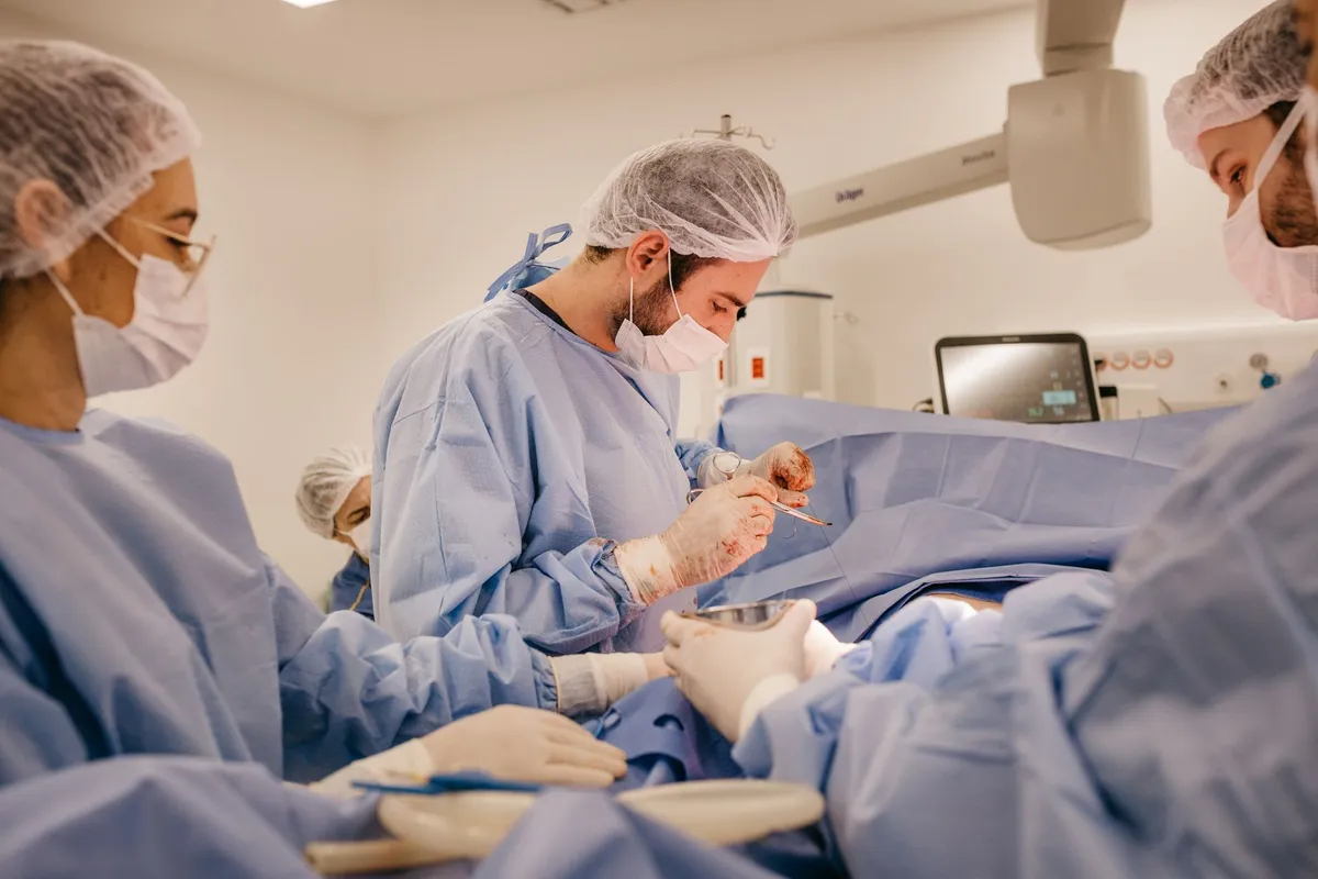 Surgeons performing a surgical procedure in an operating room.