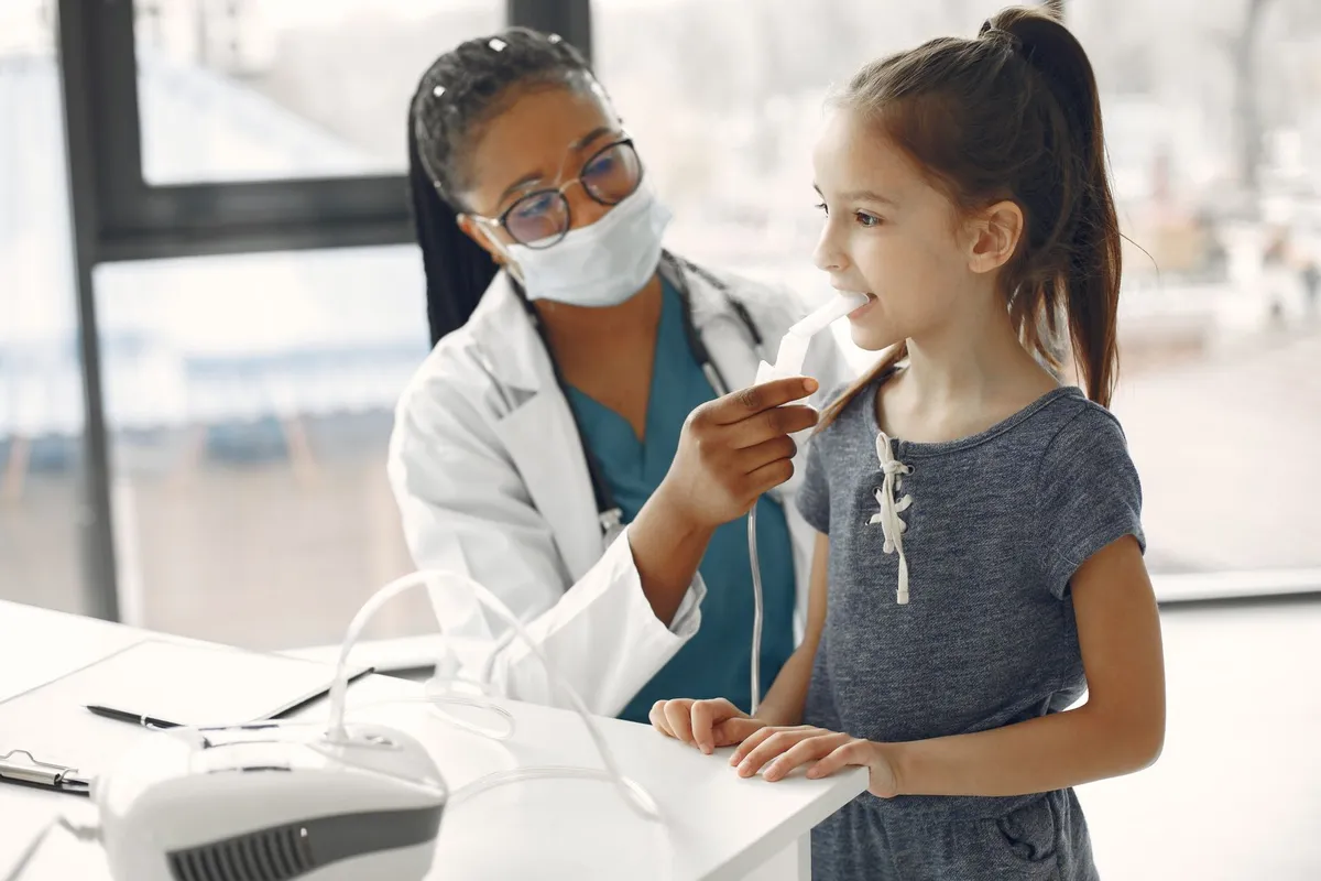 Pediatrician examining a child’s throat during a check-up for respiratory symptoms.