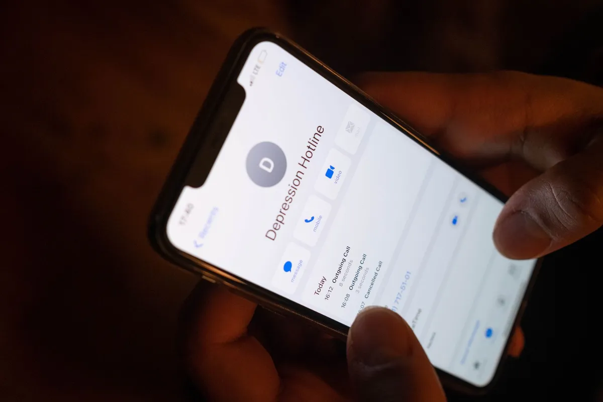 Phone screen displaying a depression hotline contact.