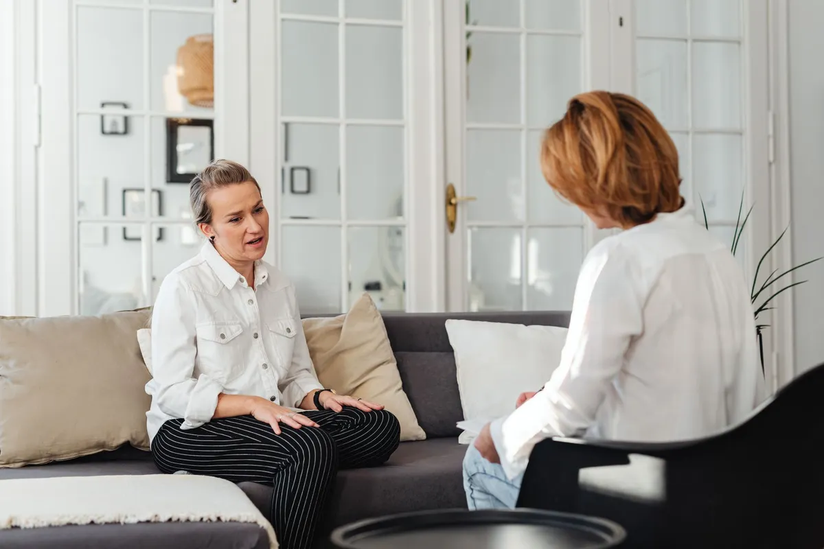 Two women engaged in a counseling session in a cozy office setting.