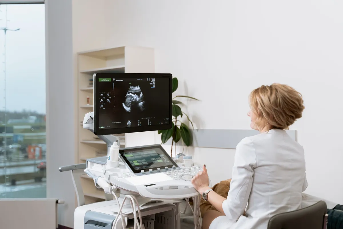 Healthcare professional reviewing an ultrasound image during a prenatal consultation.