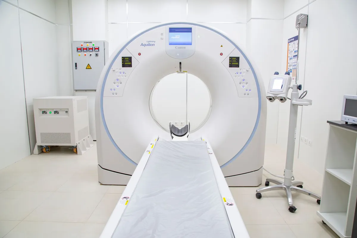 CT scan machine in a medical imaging room with a patient table.