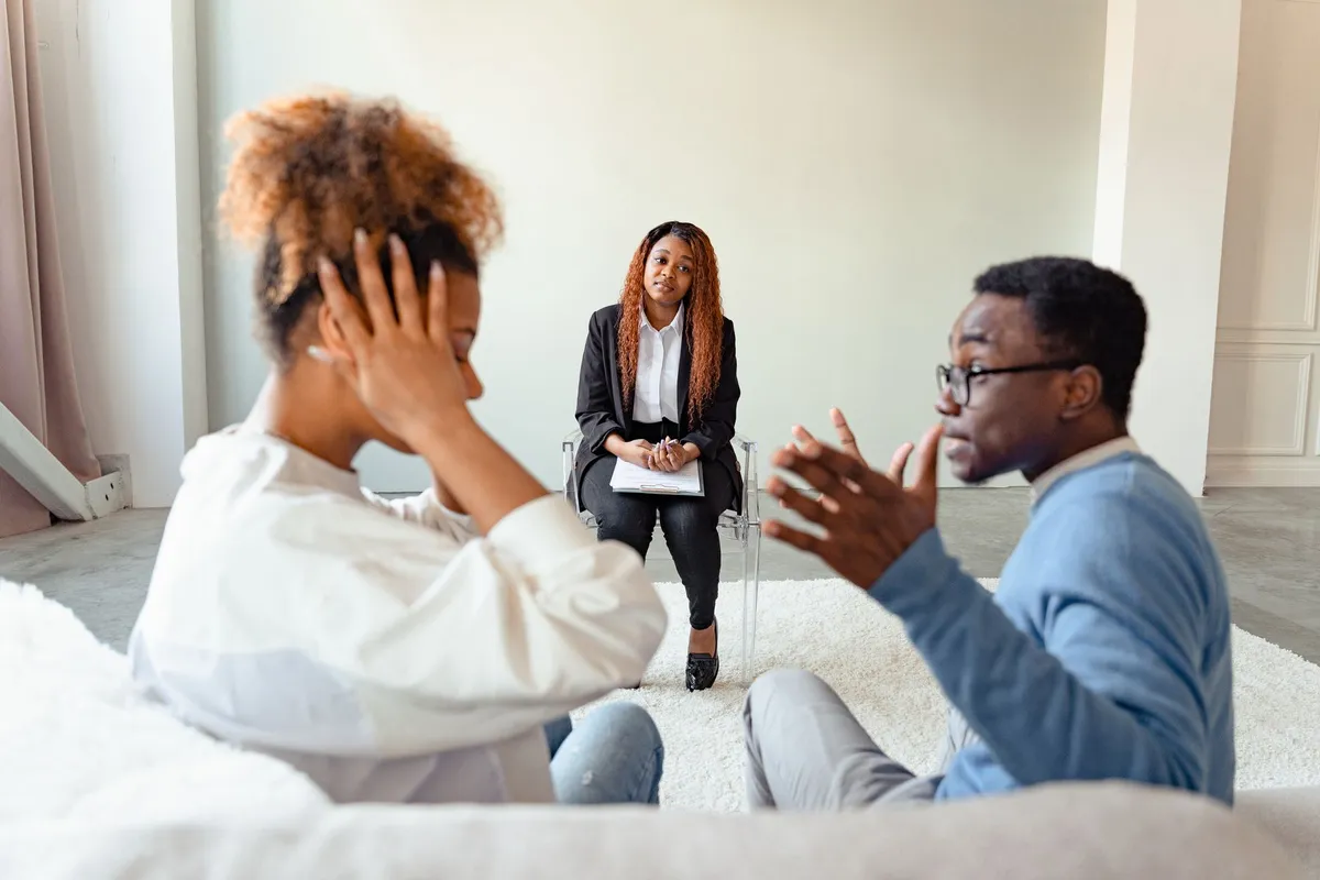 A couple discussing with a healthcare professional in a calm setting.