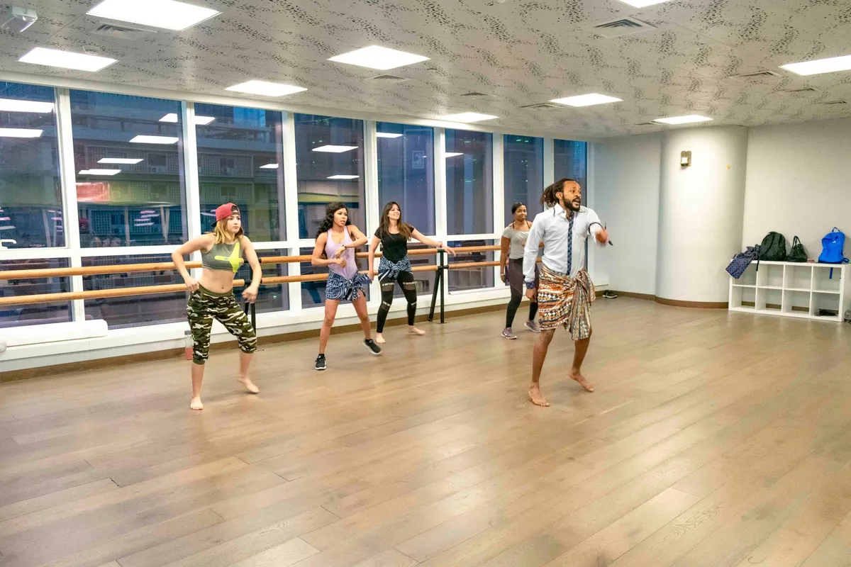Group of dancers in a studio participating in a dance class.