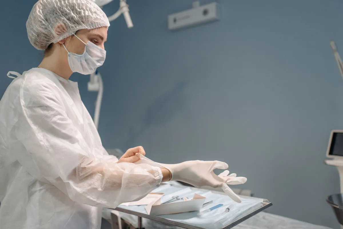 Nurse preparing surgical instruments in a clean operating room.